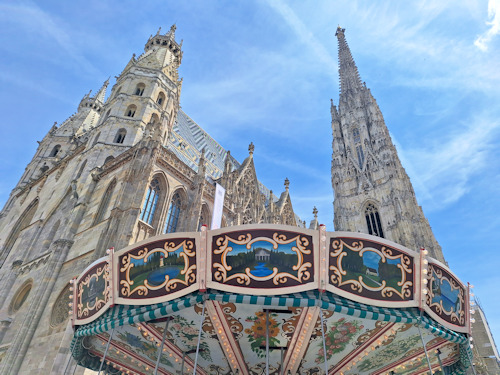 Top of a carousel with a cathedral behind
