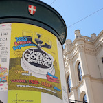 Poster advertising a coffee festival on a pillar with a historical building in the background