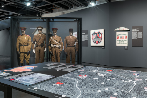Exhibition view with uniforms and map