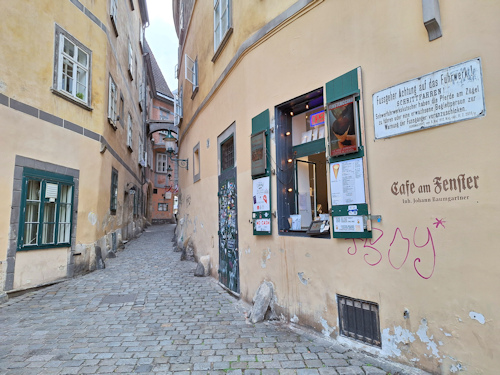 View of a café window to one side of a historical alleyway