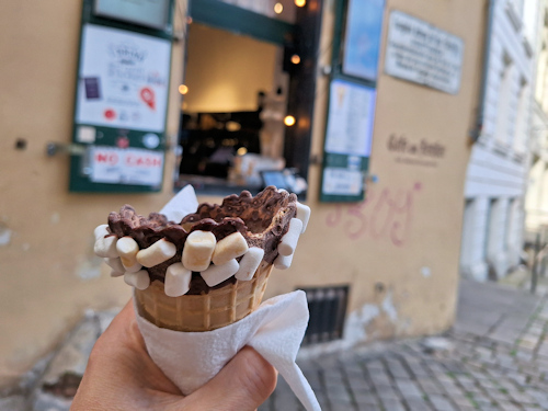 Marshmallow cone held in front of a café window