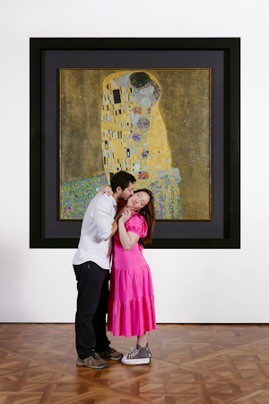 Couple kissing in front of a painting