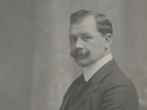 Black and white photo of a man with a mustache in 1906
