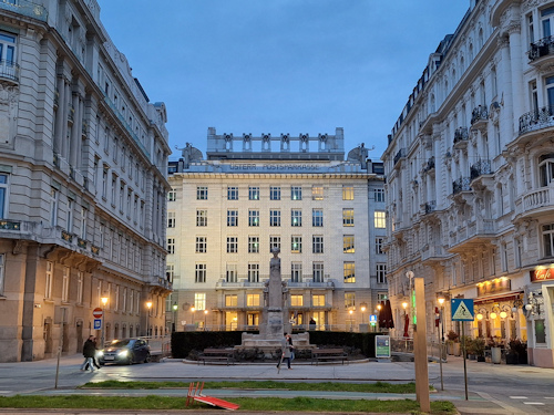Lighted Postal Savings Bank flanked by darkened old buildings