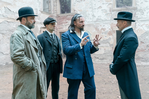 Four men in front of palais ruins