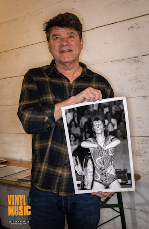 Man holding a photo of a musician