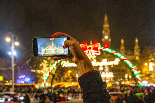Person taking a photo of a Christmas market with their phone
