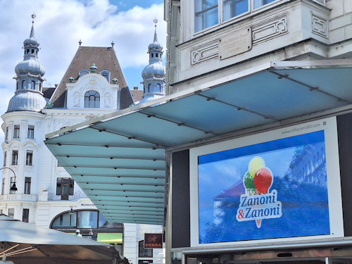 Ice cream parlour sign with a historical building behind it